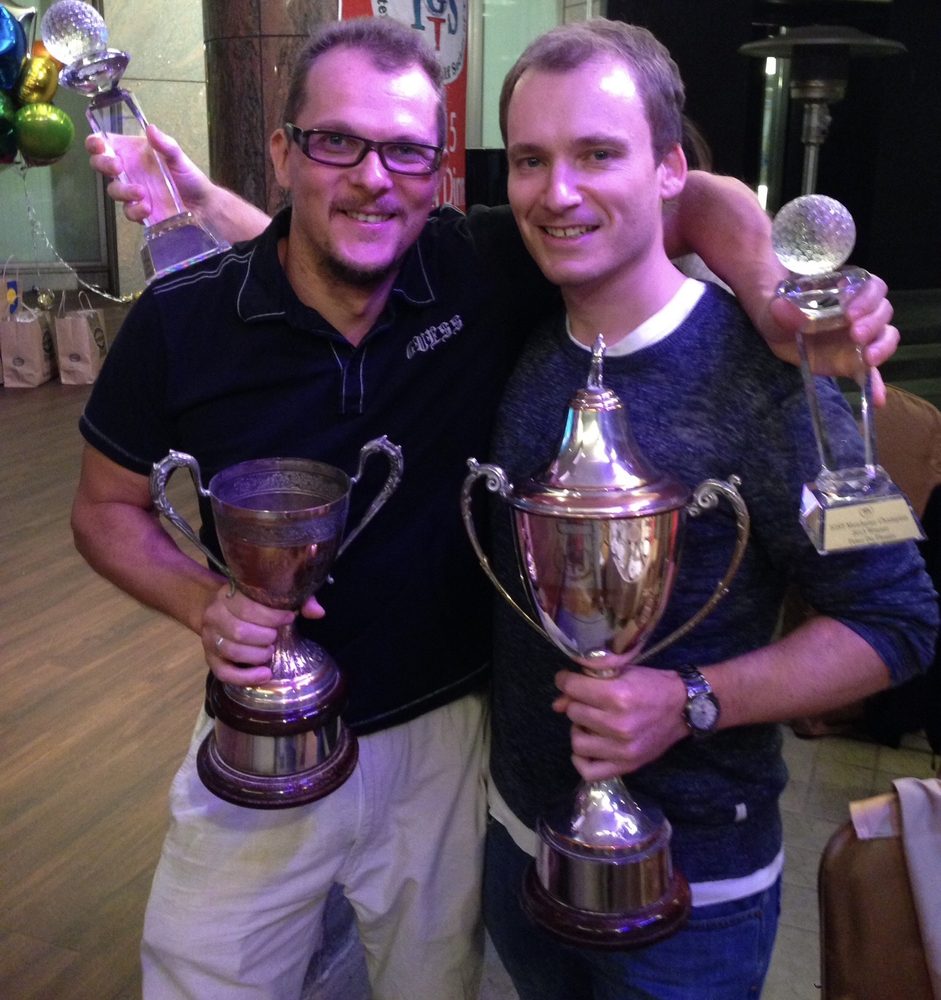 IGST members holding their trophies in front of the IGST banner